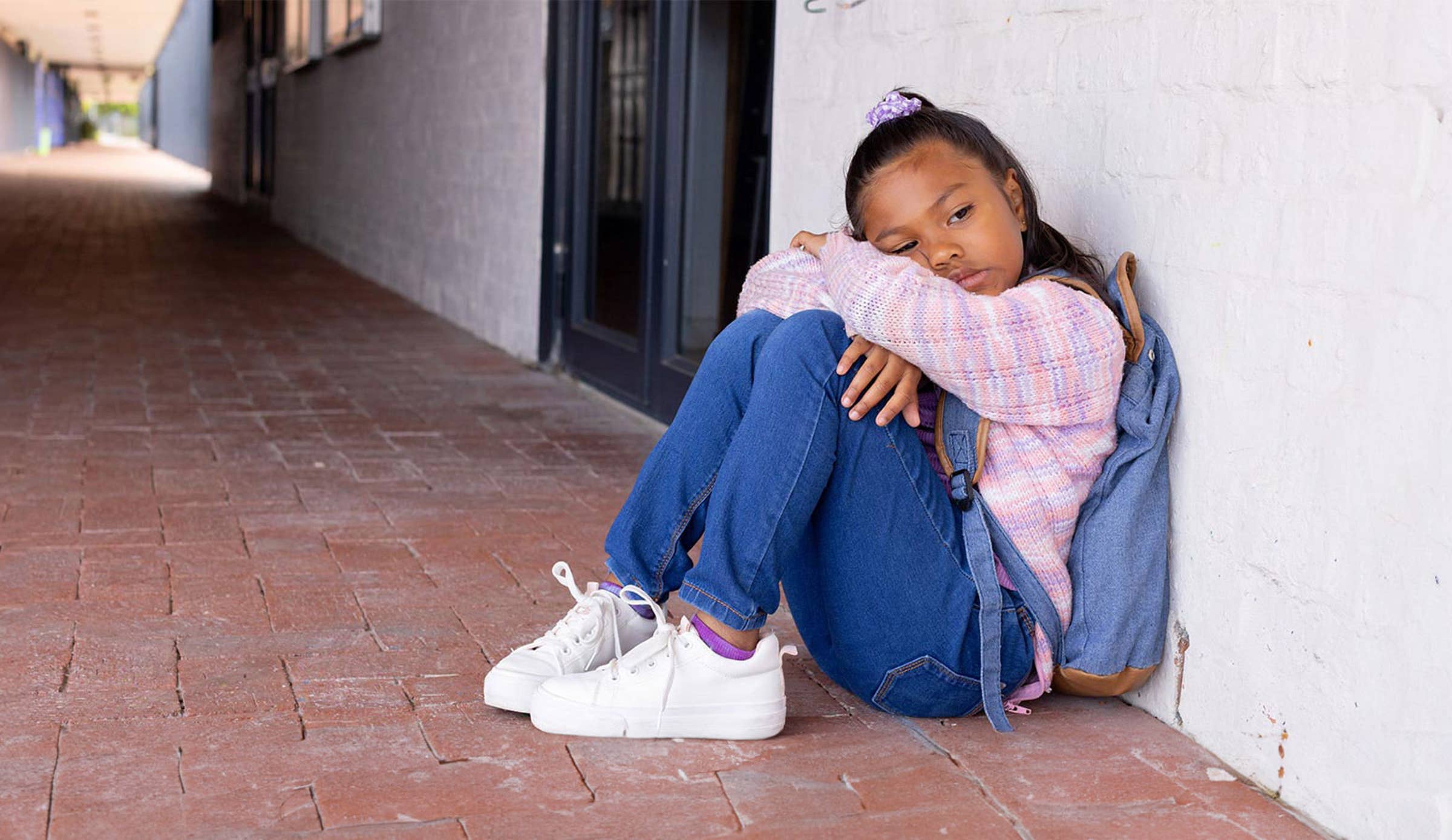 Sad girl sitting in hallway